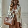 Model holding brown leather bag